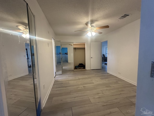 hall featuring light hardwood / wood-style flooring and a textured ceiling