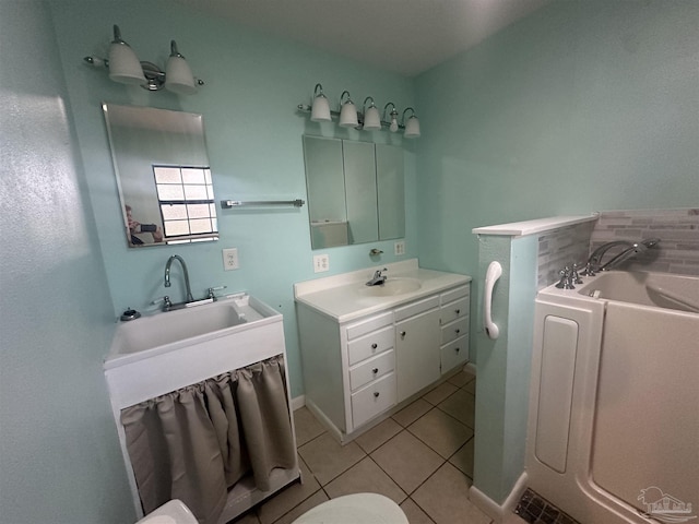 bathroom with tile patterned floors, a bathtub, and vanity