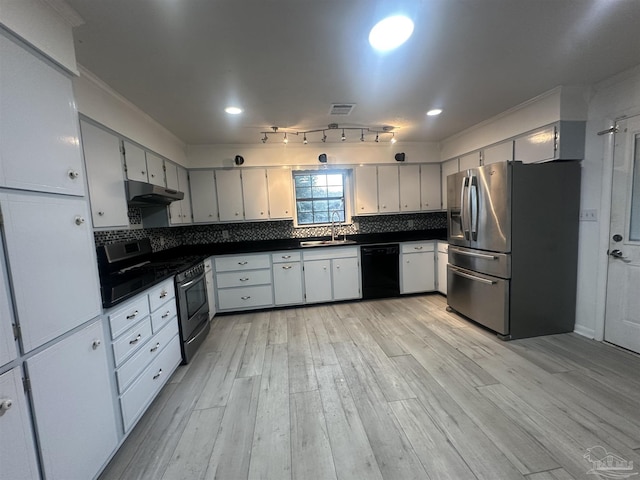 kitchen featuring tasteful backsplash, sink, light wood-type flooring, and appliances with stainless steel finishes