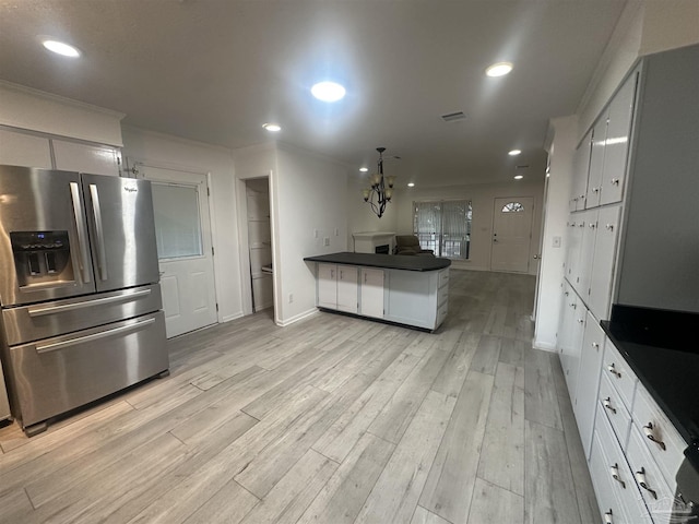 kitchen with pendant lighting, white cabinetry, ornamental molding, stainless steel refrigerator with ice dispenser, and light hardwood / wood-style flooring