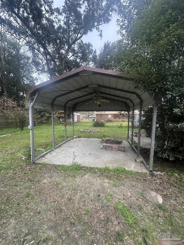 view of vehicle parking featuring a carport, a yard, and a fire pit