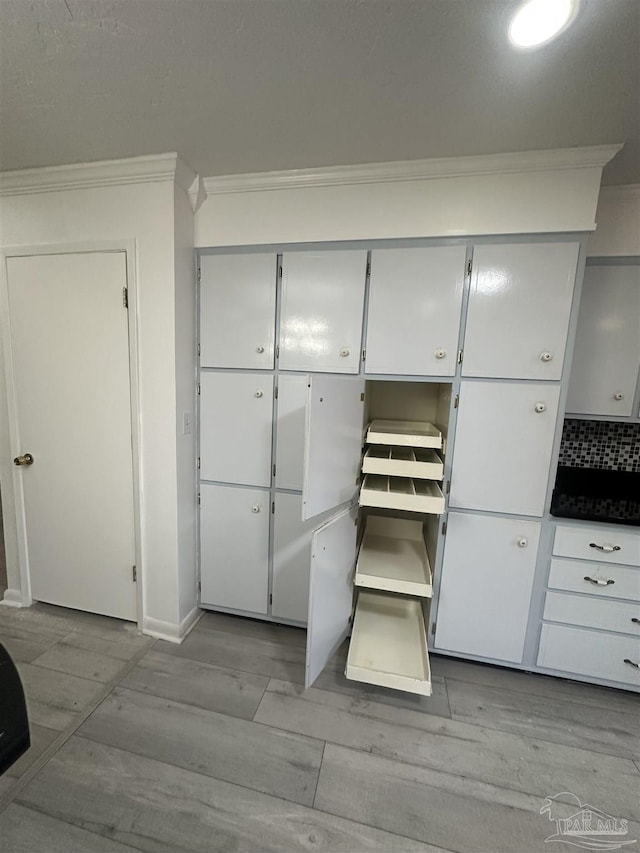 interior details featuring crown molding and hardwood / wood-style floors