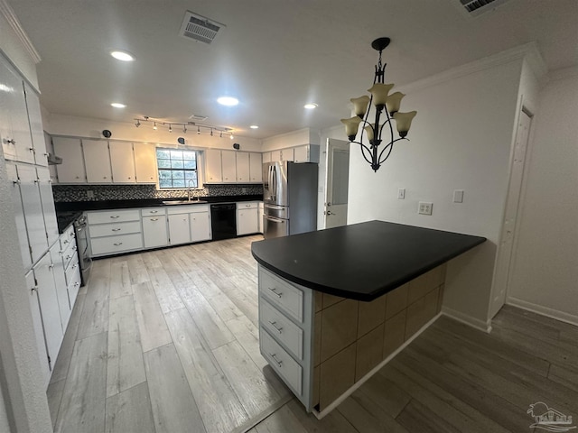 kitchen with tasteful backsplash, stainless steel appliances, kitchen peninsula, and white cabinets