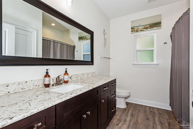 bathroom with hardwood / wood-style flooring, vanity, and toilet