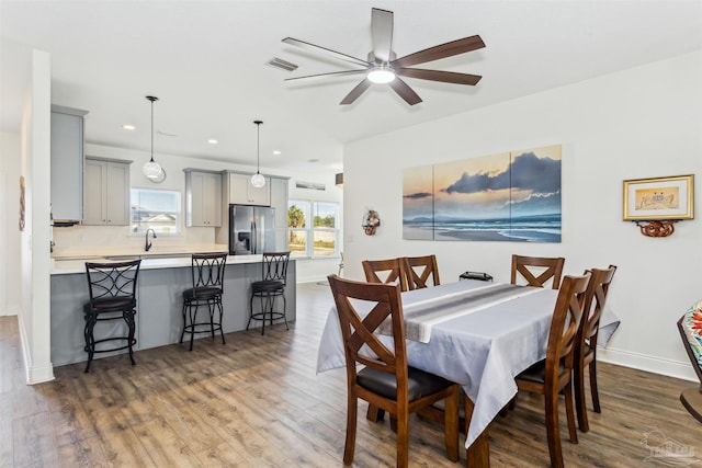 dining area with dark hardwood / wood-style floors, ceiling fan, and sink