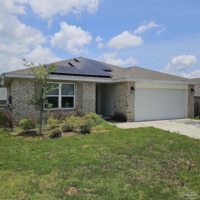 view of front of house with a garage, a front lawn, and solar panels