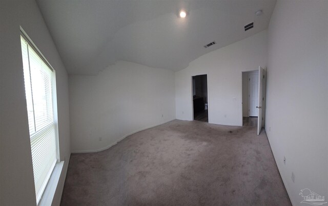 empty room with lofted ceiling and carpet floors