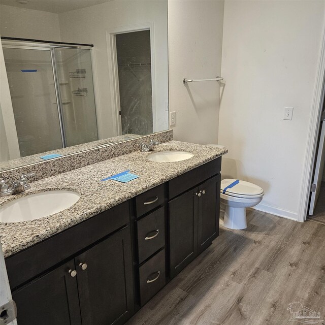 bathroom with vanity, wood-type flooring, toilet, and walk in shower