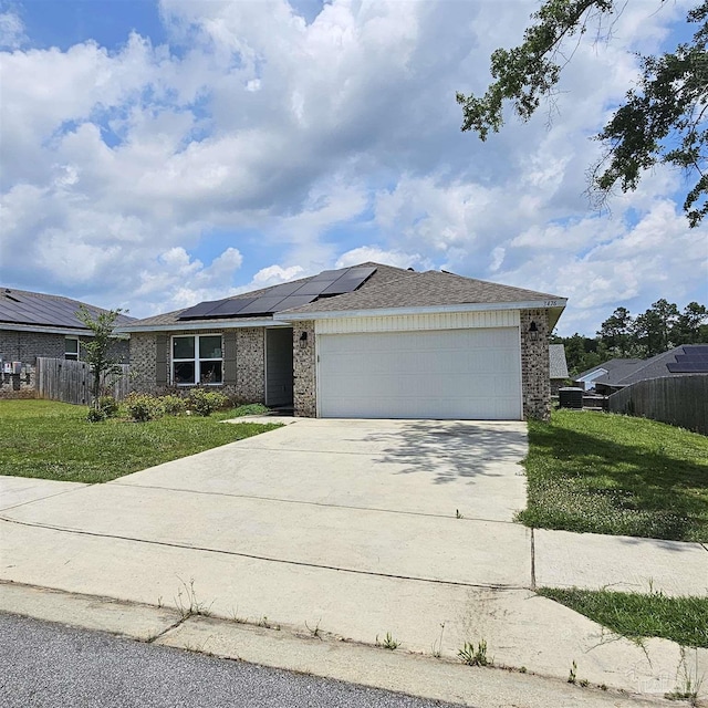 view of front of house with a garage, a front lawn, and solar panels