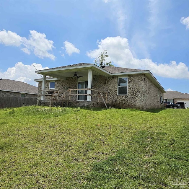 rear view of property with a yard and ceiling fan