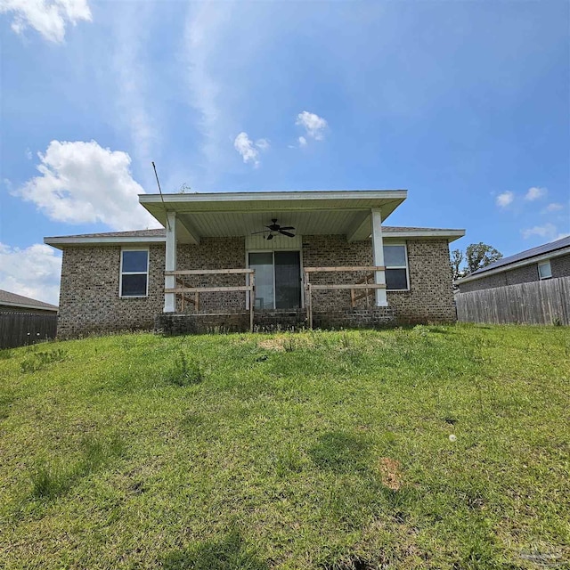 back of house featuring a yard and ceiling fan