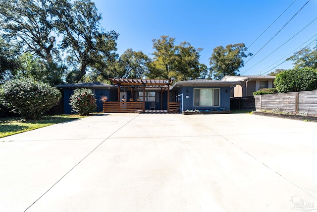 view of front facade featuring driveway and fence