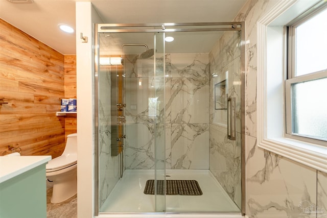 full bath with vanity, a marble finish shower, toilet, and wooden walls