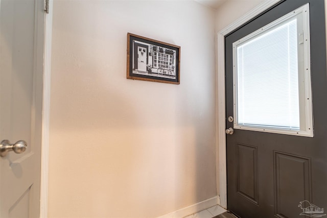 doorway to outside with baseboards