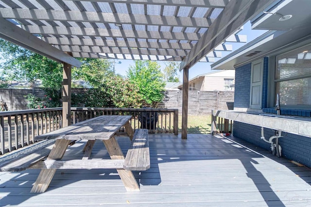 deck with outdoor dining space, a fenced backyard, and a pergola