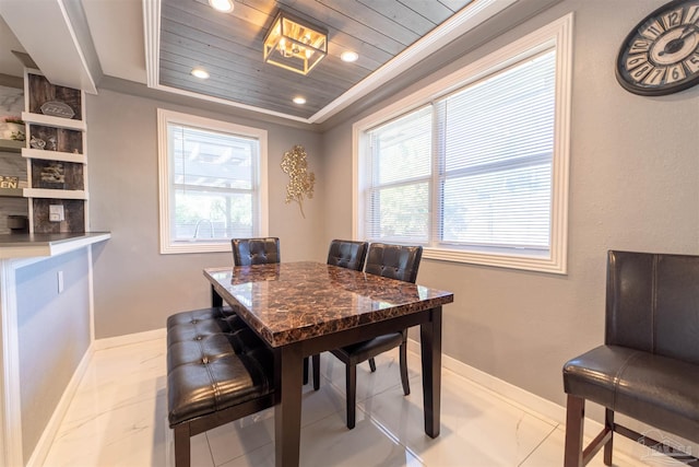 dining space featuring a wealth of natural light, wooden ceiling, a raised ceiling, and baseboards