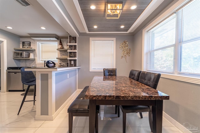 dining room featuring visible vents, ornamental molding, a raised ceiling, and baseboards