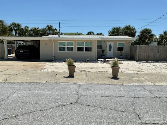 view of front of property featuring fence, driveway, and an attached carport