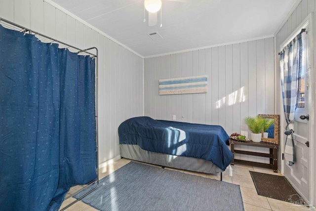 tiled bedroom with ceiling fan, crown molding, and wooden walls