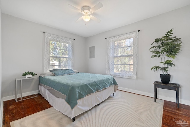 bedroom featuring ceiling fan, multiple windows, and hardwood / wood-style floors