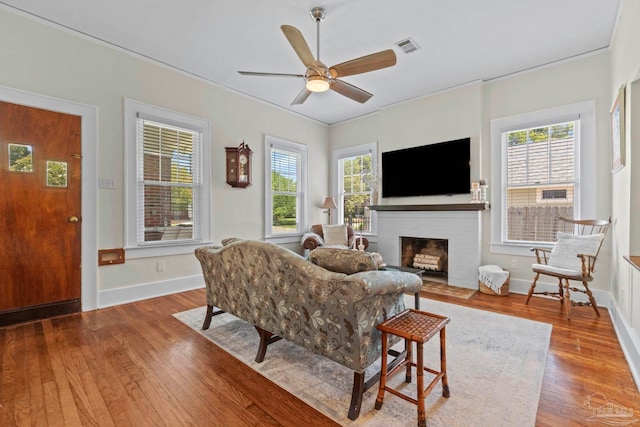 1703 E Avery St, Pensacola, FL 32503 - living room featuring wood finished floors, plenty of natural light, a brick fireplace, a ceiling fan, and crown molding