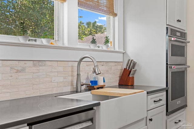 1703 E Avery St, Pensacola, FL 32503 - kitchen featuring appliances with stainless steel finishes, backsplash, white cabinets, and stainless steel counters