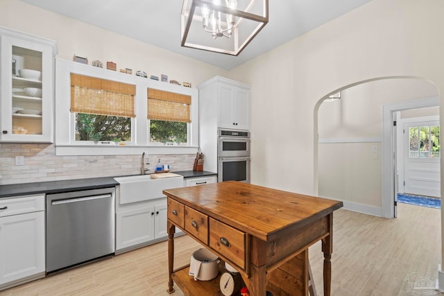 1703 E Avery St, Pensacola, FL 32503 - kitchen with appliances with stainless steel finishes, dark countertops, decorative backsplash, and white cabinets