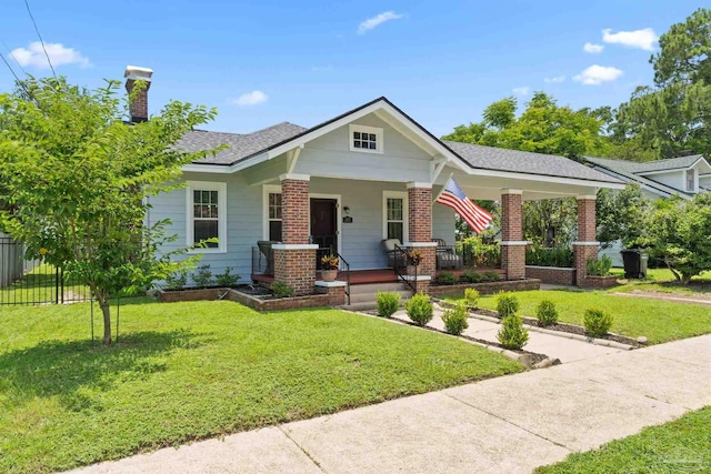 1703 E Avery St, Pensacola, FL 32503 - view of front of house with a porch, brick siding, a chimney, and a shingled roof