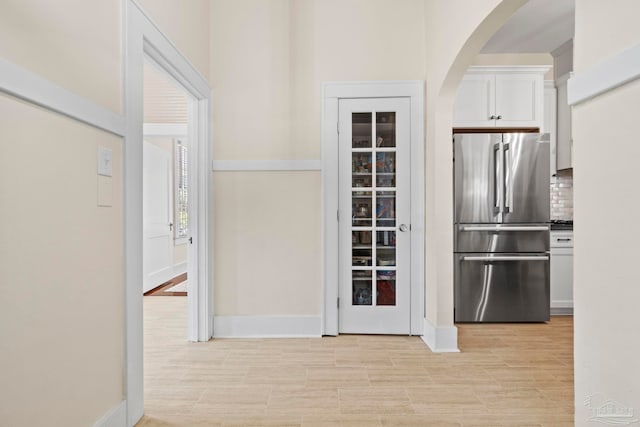 1703 E Avery St, Pensacola, FL 32503 - kitchen with freestanding refrigerator, arched walkways, white cabinets, and backsplash