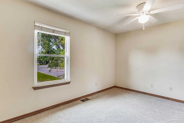 carpeted spare room featuring a textured ceiling and ceiling fan