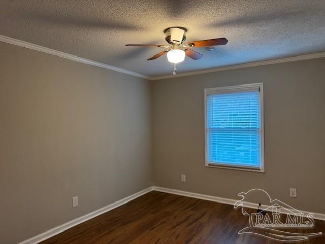 empty room featuring a ceiling fan, baseboards, dark wood finished floors, and crown molding