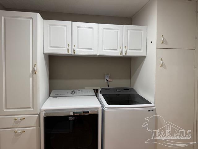 laundry area featuring separate washer and dryer and cabinet space