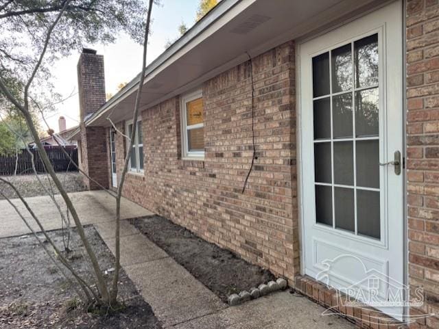 view of home's exterior with a chimney and brick siding