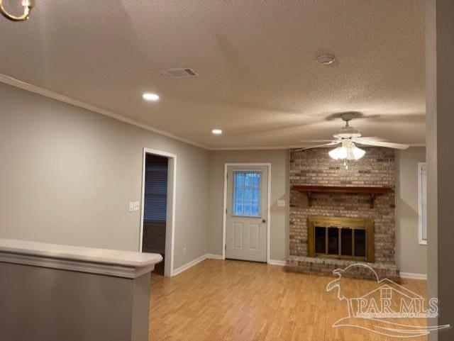 unfurnished living room with a textured ceiling, a fireplace, wood finished floors, a ceiling fan, and baseboards