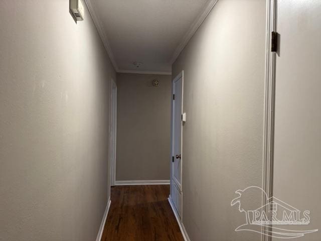 hall featuring baseboards, ornamental molding, and wood finished floors