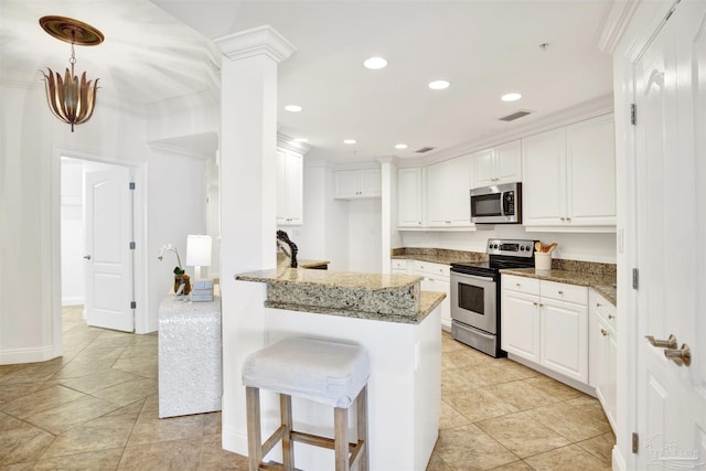 17075 Perdido Key Dr Unit 4E, Pensacola, FL 32507 - kitchen with stainless steel appliances, a peninsula, light stone countertops, white cabinets, and a breakfast bar