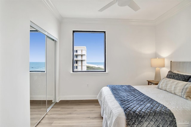 17075 Perdido Key Dr Unit 4E, Pensacola, FL 32507 - bedroom featuring wood finished floors, a closet, baseboards, ornamental molding, and a ceiling fan