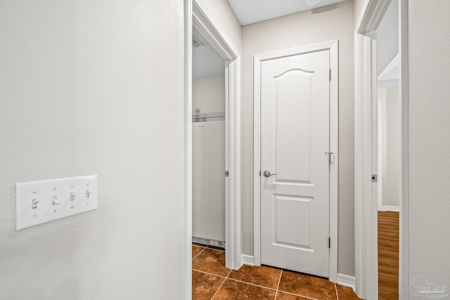 corridor with dark tile patterned flooring