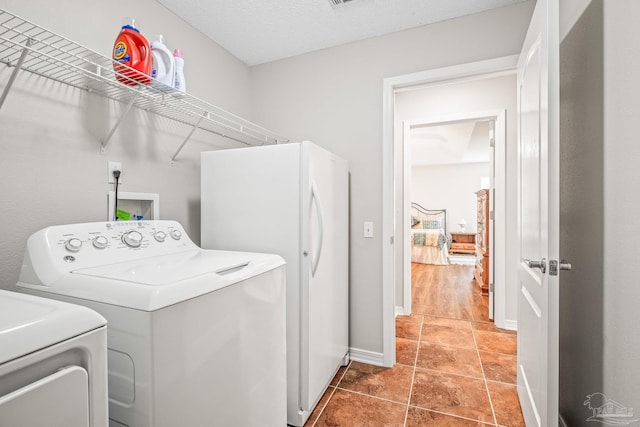 laundry area with tile patterned floors and independent washer and dryer