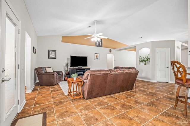 tiled living room featuring ceiling fan and lofted ceiling