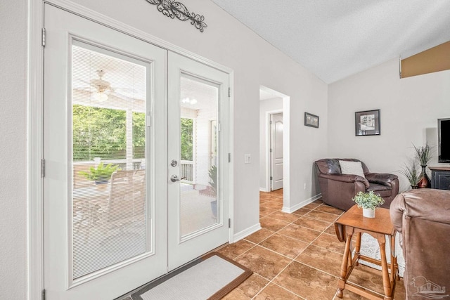 doorway to outside with french doors, a textured ceiling, vaulted ceiling, and light tile patterned floors