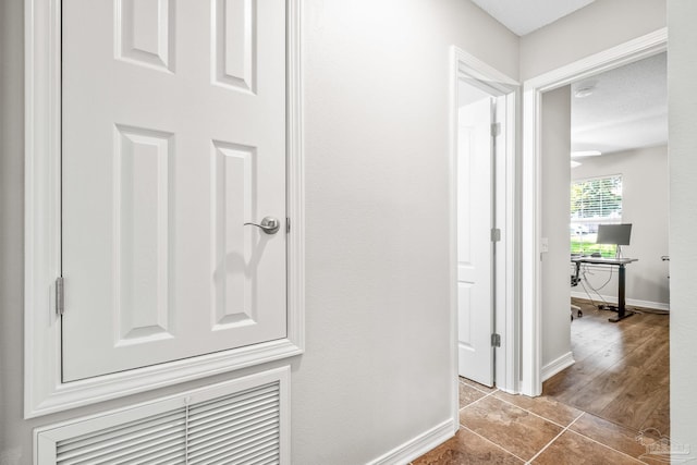 corridor featuring hardwood / wood-style flooring and a textured ceiling