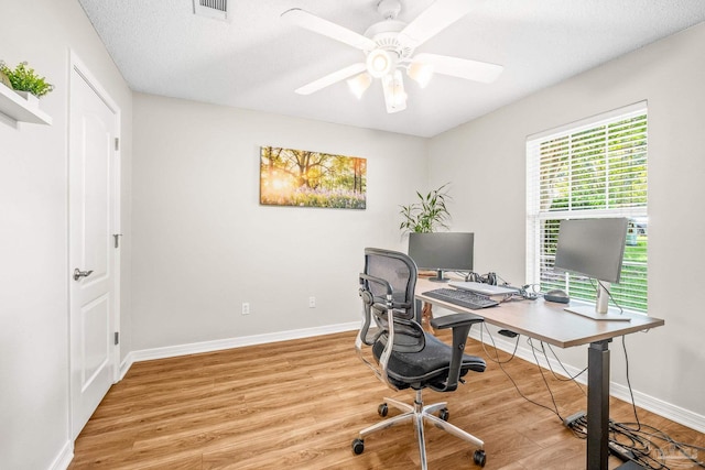 office area with a textured ceiling, light hardwood / wood-style flooring, and ceiling fan