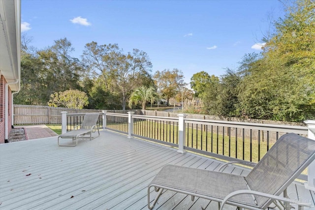 wooden deck featuring a lawn