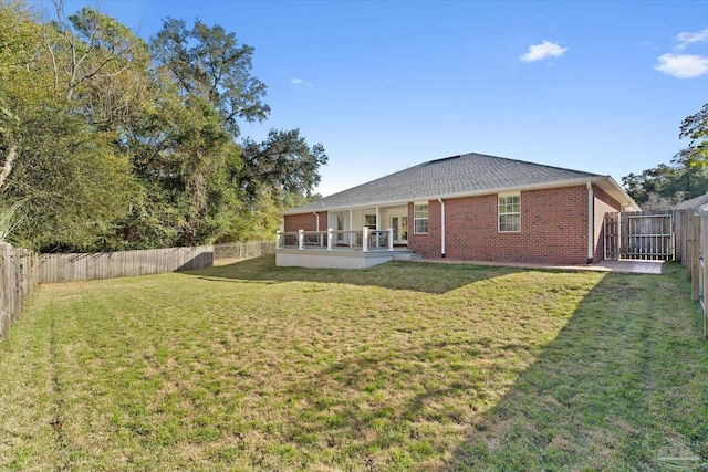 back of property featuring a lawn and a deck