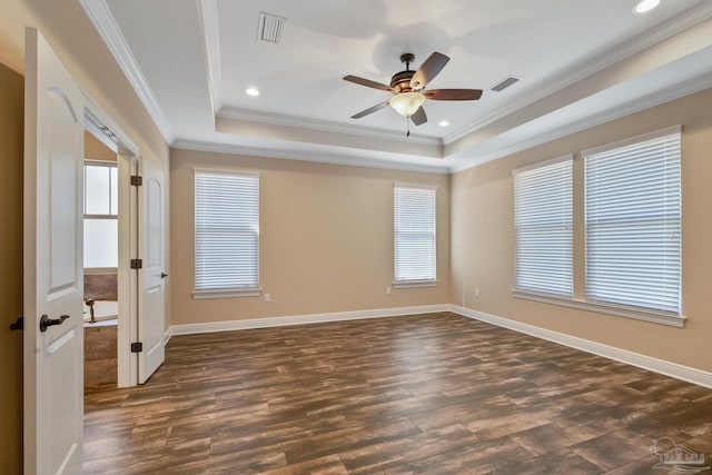 unfurnished room with dark hardwood / wood-style flooring, a tray ceiling, ornamental molding, and ceiling fan