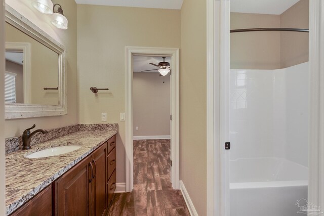 bathroom featuring vanity, hardwood / wood-style flooring, and  shower combination