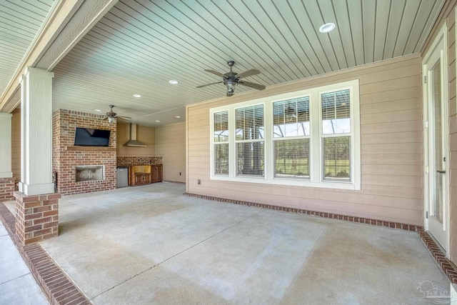 view of patio with an outdoor brick fireplace, ceiling fan, and an outdoor kitchen