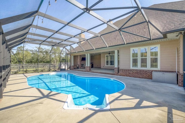 view of pool with a patio, ceiling fan, and glass enclosure