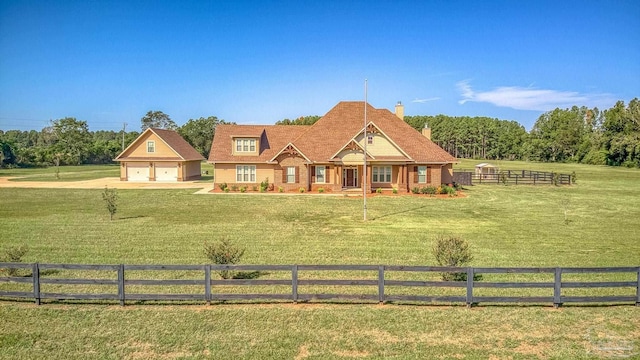 view of front facade with a rural view, a garage, and a front lawn